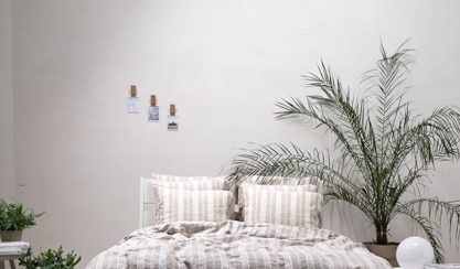 Guest bedroom with striped linen bedding and houseplants