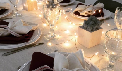 Festive table setting with linen napkins and string lights