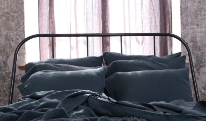 Dark grey linen bedding on a metal bed