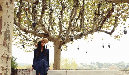 Models wearing dark linen clothing beneath autumn trees