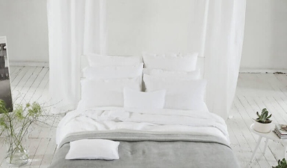 White linen bedding in a naturally styled bedroom