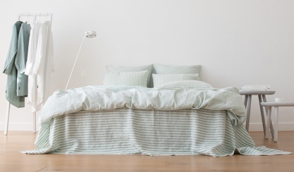 Pale green linen bedding in a bright bedroom