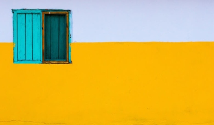 Turquoise window in a yellow wall