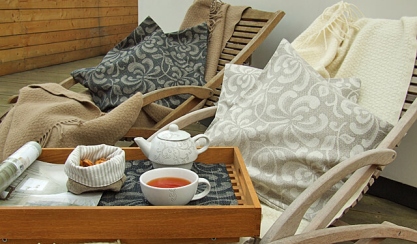Terrace chair with patterned cushions, throws and tea tray