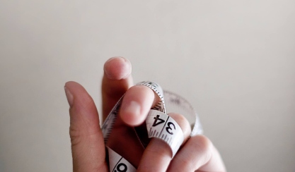 Hand holding a flexible measuring tape