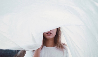 Person holding a folded white linen textile