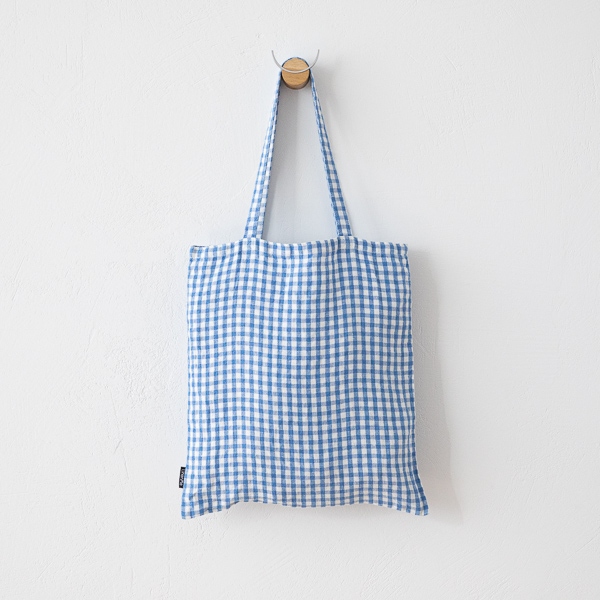 Blue gingham linen tote bag hanging front view on a wall hook
