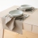 Natural Rustic linen fabric draped over a dining table with tableware