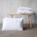 Optical-white linen cushions beside a wooden bench