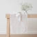 Optical-white linen table runner and napkin on a wooden table