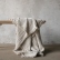 Natural linen throw draped over a wooden bench