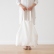 Woman holding an off-white Terra linen shopping bag by the handles