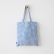 Blue gingham linen tote bag hanging front view on a wall hook